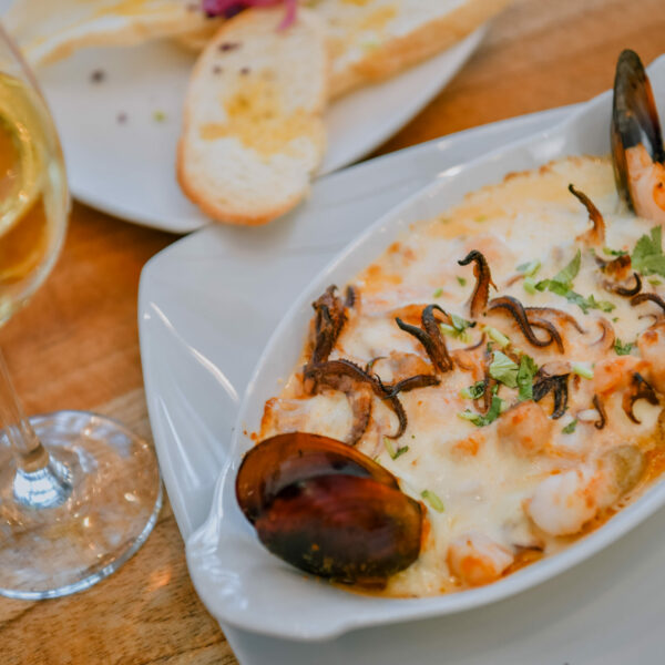 Deliciosa cama de papas babys con filete de pescado, camarones, calamar y almejas aromatizada con vino blanco bañados de queso mozarella con crema, que al gratinar hace una sinfonía de sabores.